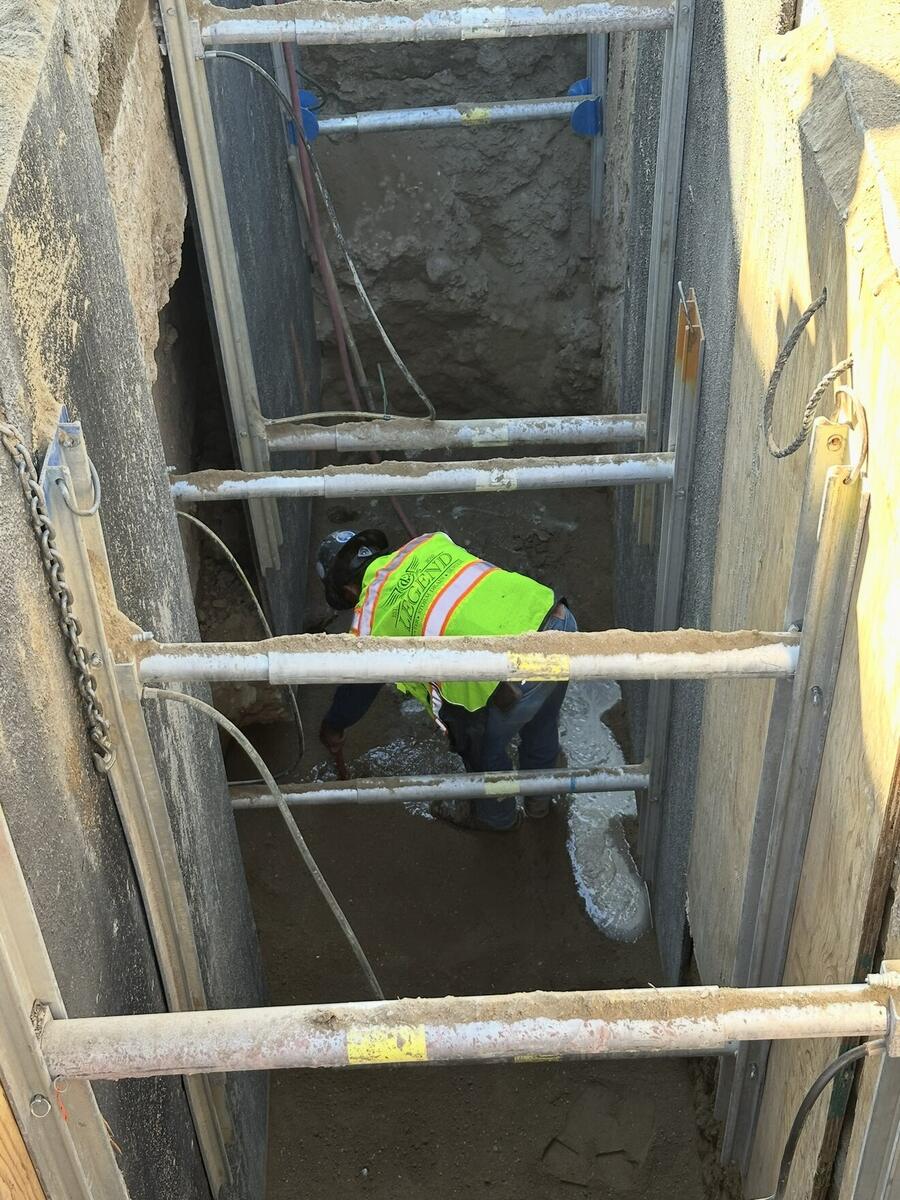 Crew member in a shored trench during a sewer repair installation