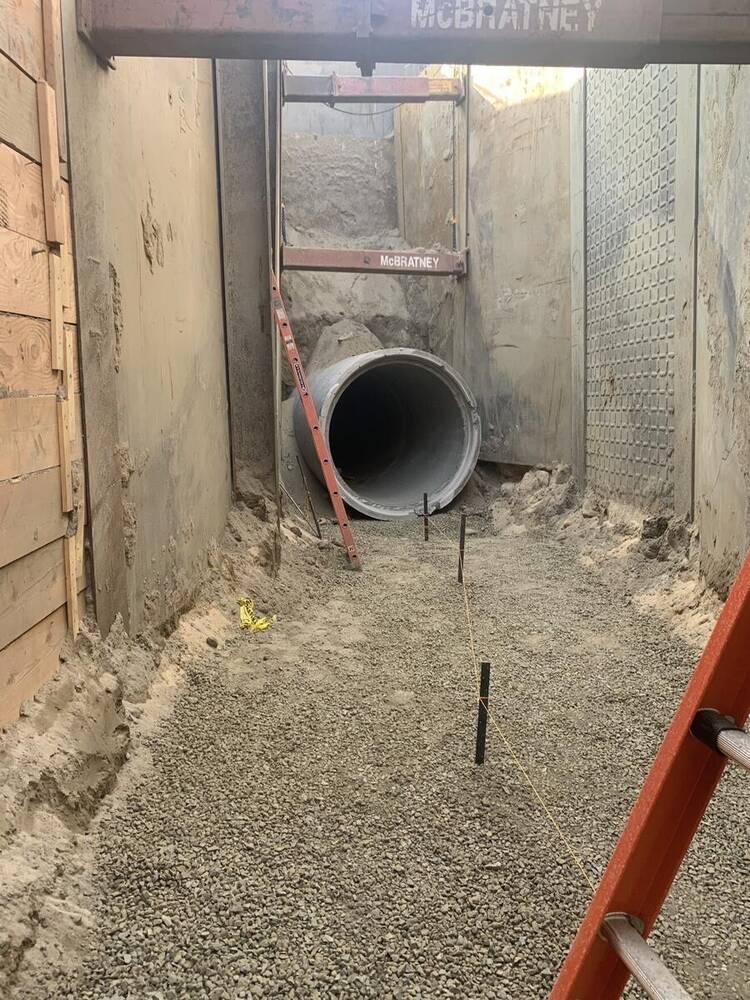 Large-diameter concrete storm drain pipe installed in a deep trench at an industrial logistics development